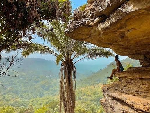 A visitor on the rock ledge at Umbrella Rock, above the valley below