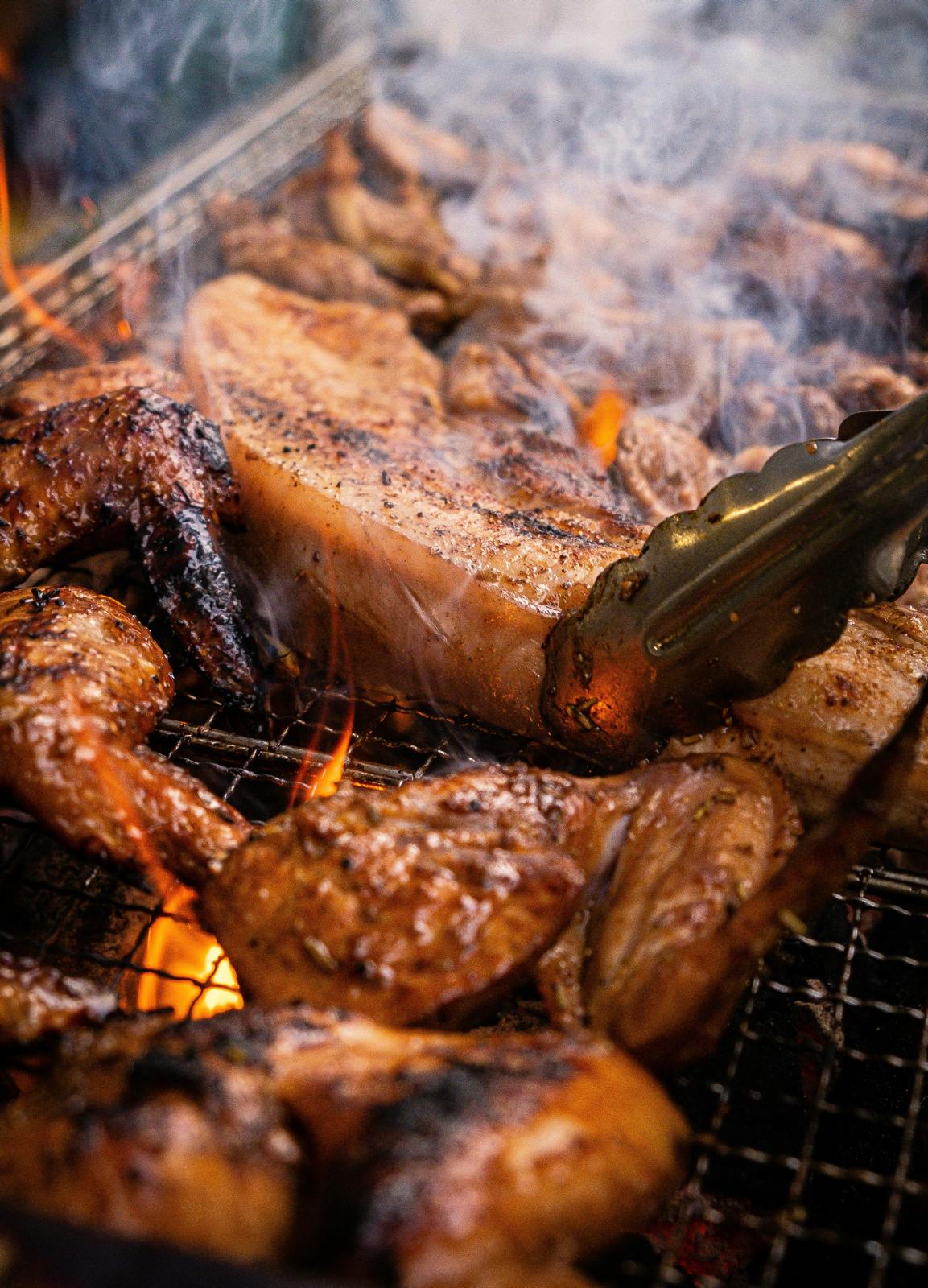 Seasoned meat sizzling on a charcoal grill