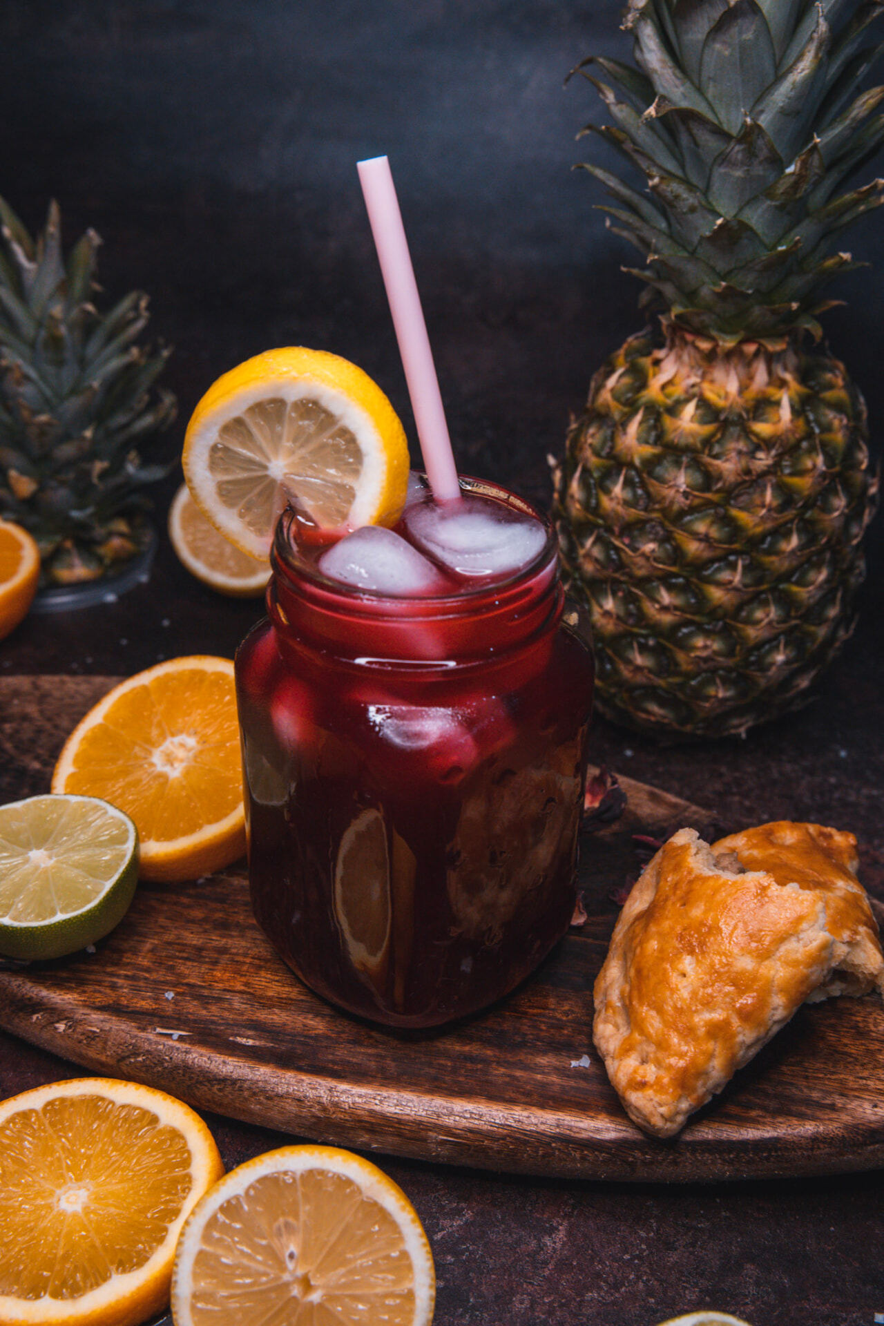 A glass of chilled sobolo with citrus slices and a golden pastry