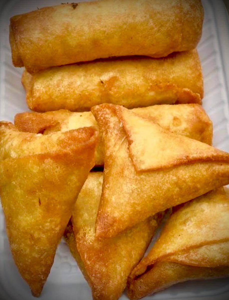 Crisp samosas and spring rolls served in a tray