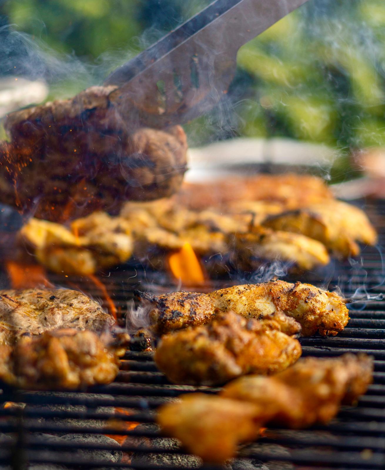 Chicken and skewers cooked over open flames on an outdoor grill