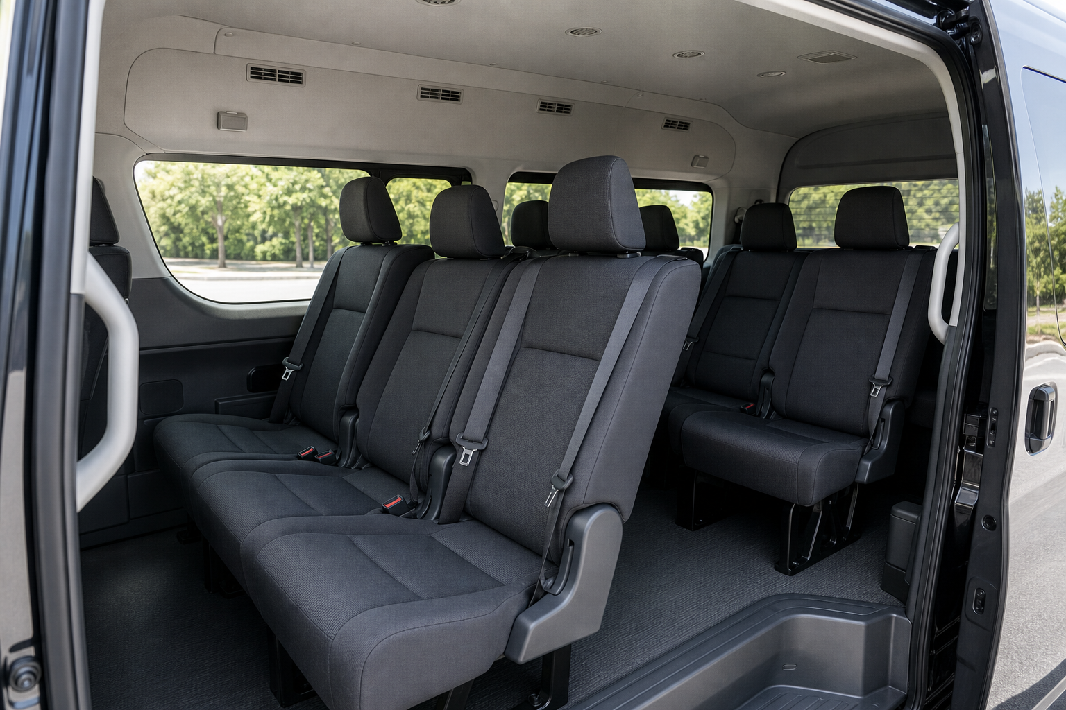 The passenger cabin of a JATA Tours minibus, seen through the open sliding door