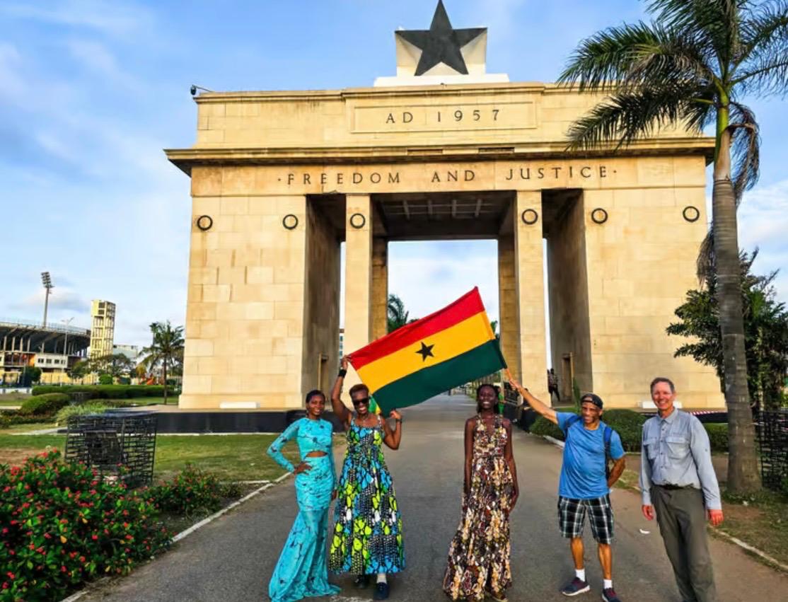 A group holding the Ghana flag in front of the Independence Arch