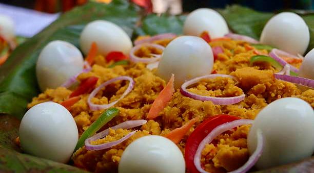 Mashed yam served on banana leaves with boiled eggs and peppers