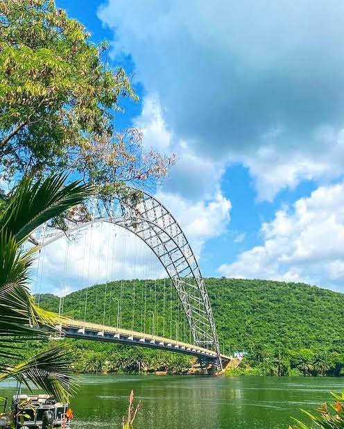 The Adomi Bridge stretching across the Volta River, seen from the riverbank