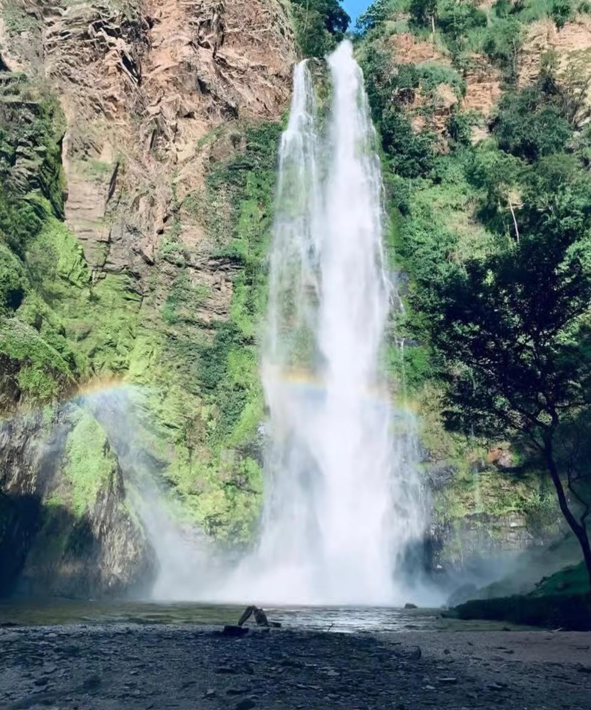 Tagbo Falls dropping into its pool with a rainbow in the mist