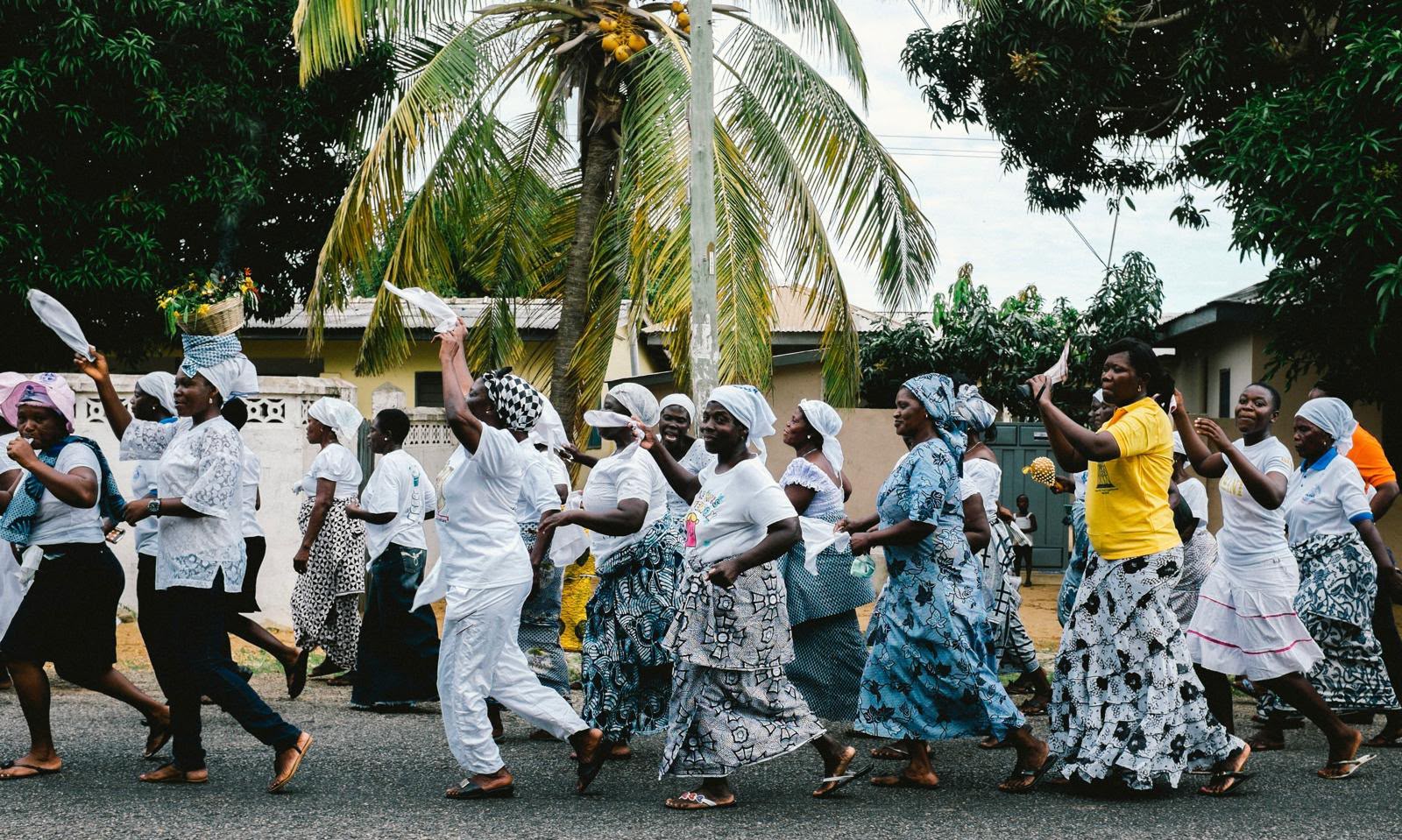A street procession moving through a Ghanaian town